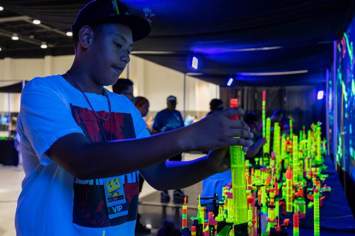 Louis Kemp V, 12, builds a tower with the glow-in-the-dark Legos at the Brick Fest Live on Sunday, Oct. 2, 2022, at SAFE Credit Union Convention Center in downtown Sacramento.