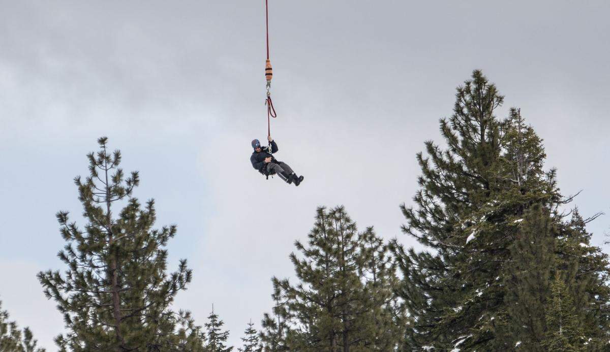 Pat Lansing, a lineman with Wasatch Electric, is lowered from a helicopter in Truckee earlier this month. The recent heavy snow in the Sierra caused power outages to many homes and transporting workers by helicopter is the easiest way to get them to remote places.