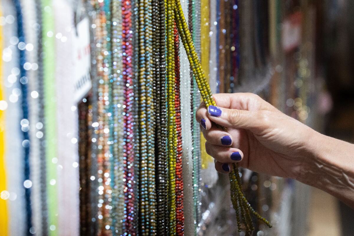 A customer feels a string of beads during the Gem Faire at the Scottish Rite Masonic Center in Sacramento on Friday, Aug. 2, 2024. Visitors could explore the Gem Faire’s myriad booths of crystals, gemstone artwork and jewelry.