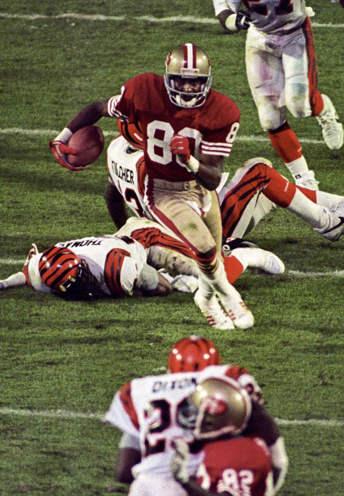 San Francisco 49ers wide receiver Jerry Rice (80) carries the ball against the Cincinnati Bengals during Super Bowl XXIII at Joe Robbie Stadium in Miami, Florida. The 49ers defeated the Bengals 20-16.