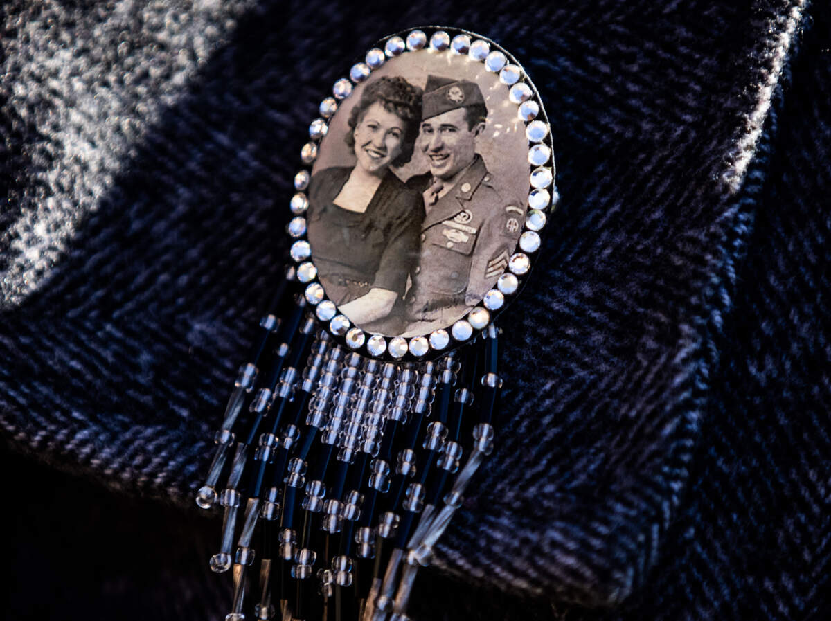 A photo of Marvin D. Cornett and his wife Eloyce Cornett is pinned on daughter Jan Mendoza’s coat on Monday. Marvin and Eloyce met after the Army paratrooper was injured in Italy and returned to Ft. Benning as a jump instructor, where she worked as a parachute rigger. The couple moved to California with their daughters after Marvin retired from the Army in 1968.