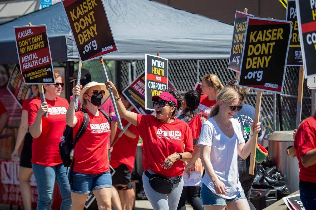 Social worker Amalia Marroquin, center, yells chants to cars passing during a strike involving mental health clinicians represented by the National Union of Healthcare Workers on Monday, Aug. 15, 2022, at Kaiser Permanente Sacramento Medical Center and Medical Offices on Morse Avenue in Arden Arcade.