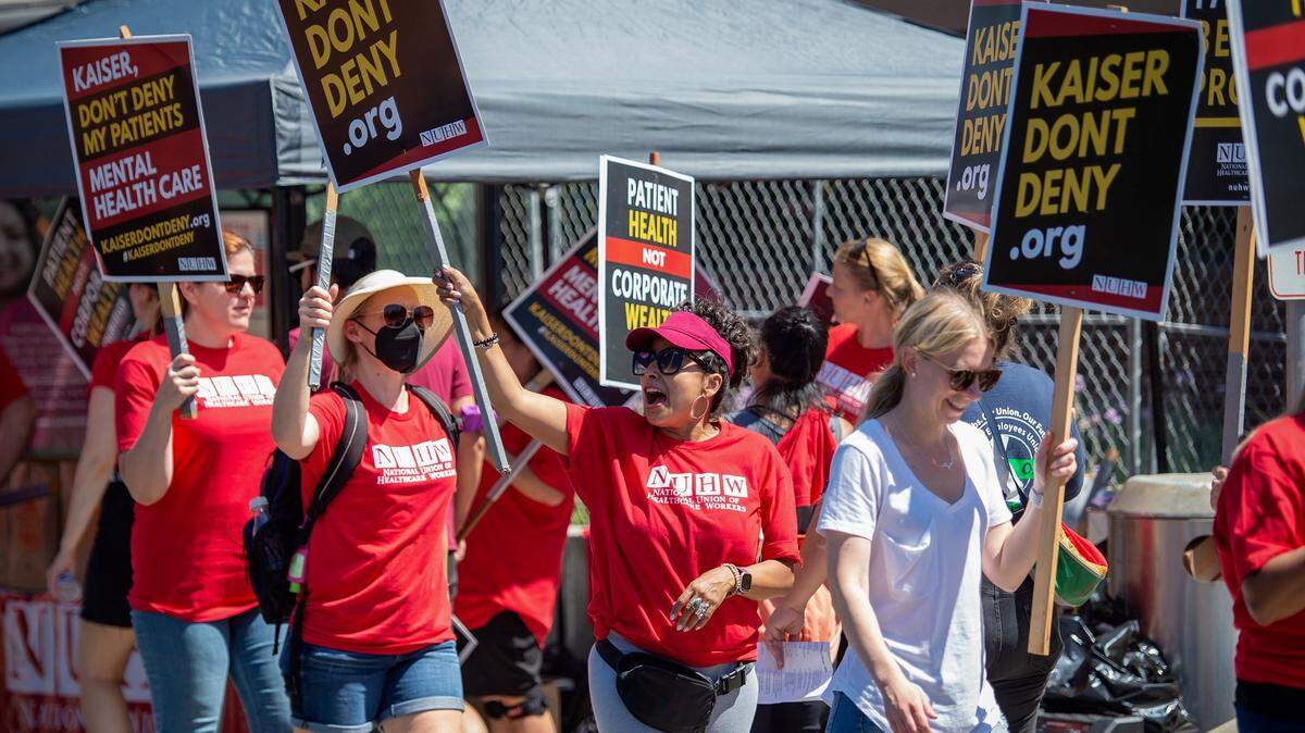 Social worker Amalia Marroquin, center, yells chants to cars passing last month during a strike involving mental health clinicians represented by the National Union of Healthcare Workers at Kaiser Permanente Sacramento Medical Center in Sacramento. The two sides have agreed to have Sacramento Mayor Darrell Steinberg mediate their stalled contract talks.