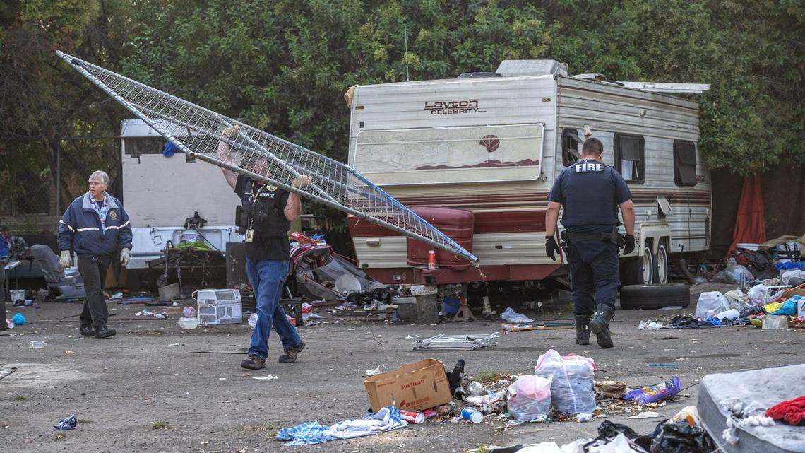 Sacramento city building inspector Jason Martinoni carries a fence away on Sept. 20 during a homeless encampment sweep on 1st Avenue in Sacramento. The women who live in the trailer said they felt safe there with their dogs, and worried about where they would relocate. City officials proposed the tent-only Miller Park Safe Ground site.