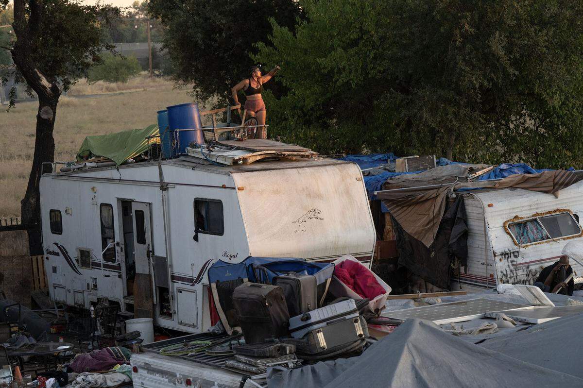 A resident of Camp Resolution works to secure some of her possessions on her trailer before the city of Sacramento came to remove the homeless encampment on Monday.