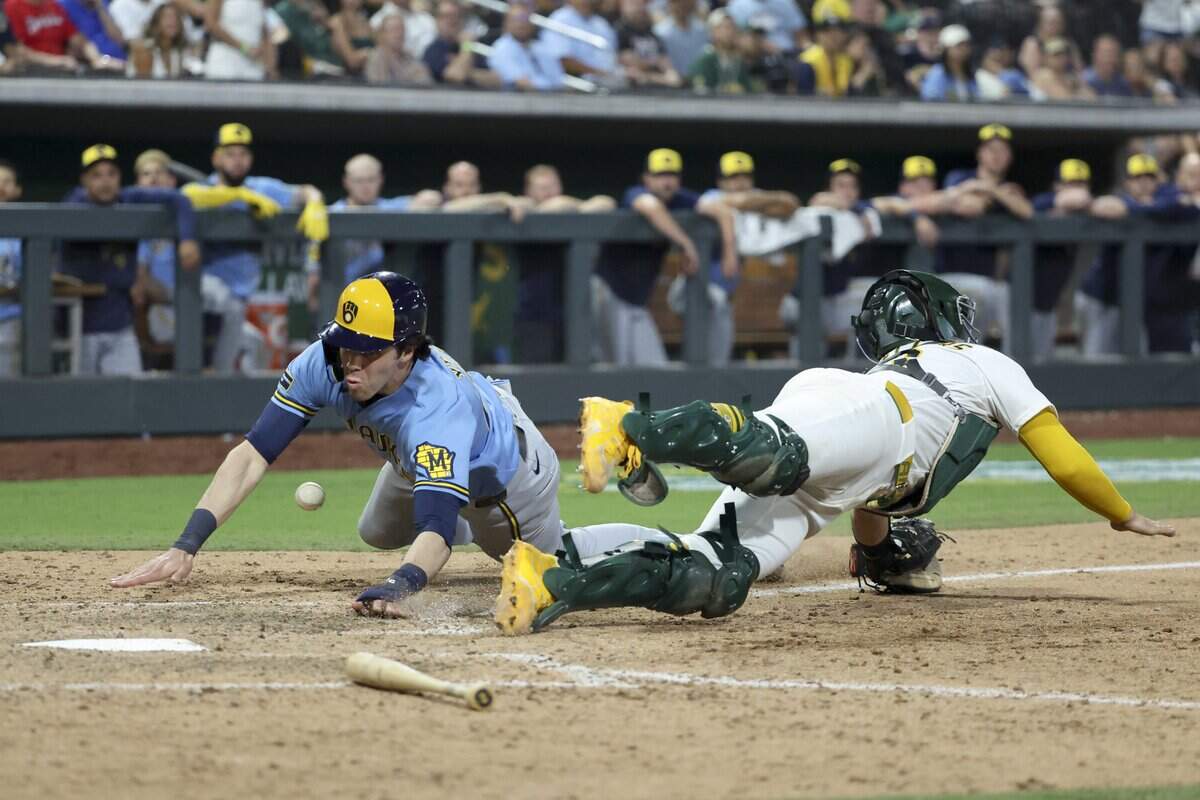 LAS VEGAS, NEVADA - JUNE 08: Christian Yelich #22 of the Milwaukee Brewers slides past Shea Langeliers #23 of the Athletics while scoring a run during the 12th inning of a game at Las Vegas Ballpark on June 08, 2026 in Las Vegas, Nevada. (Photo by Ian Maule/Getty Images)