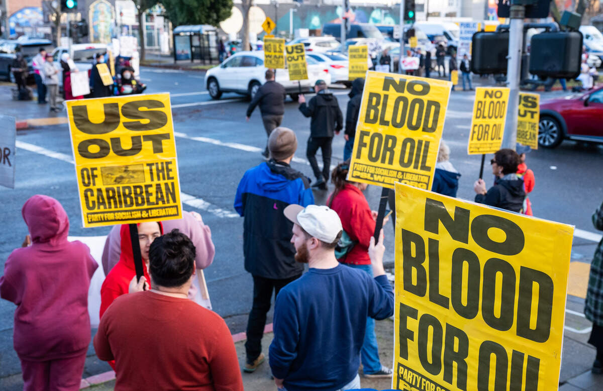Protesters demonstrate on the corners of 16th and J streets near the Memorial Auditorium in Sacramento on Saturday against U.S. military action in Venezuela after President Donald Trump announced a bombing raid on the country and the capture of its leader.