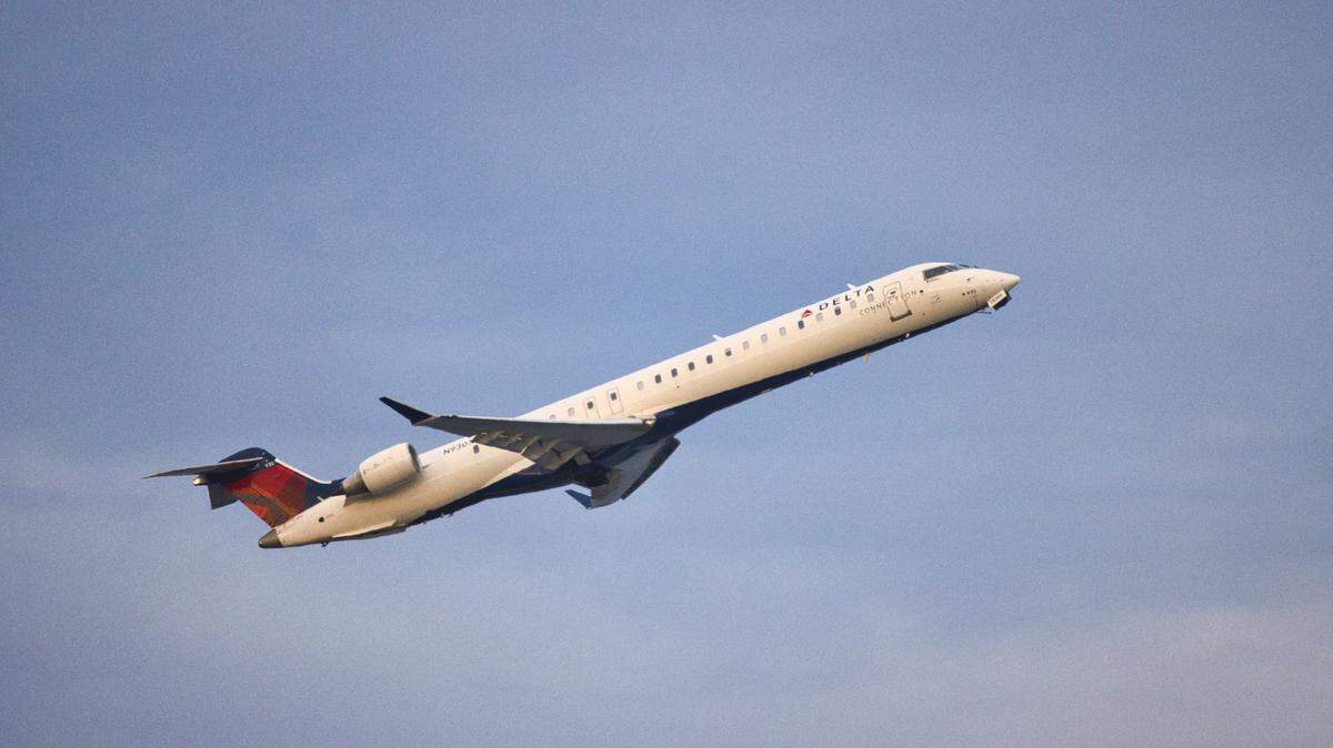 A Delta Air Lines co-pilot authorized to carry a firearm threatened to shoot a pilot if he diverted a flight for a medical emergency, federal officials say.