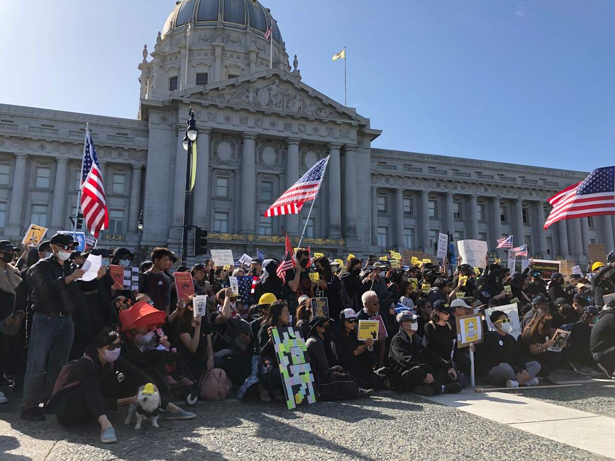 Protesters gathered for a photo at the “San Francisco Stands with Hong Kong” rally on Sunday at the Civic Center Plaza in San Francisco.