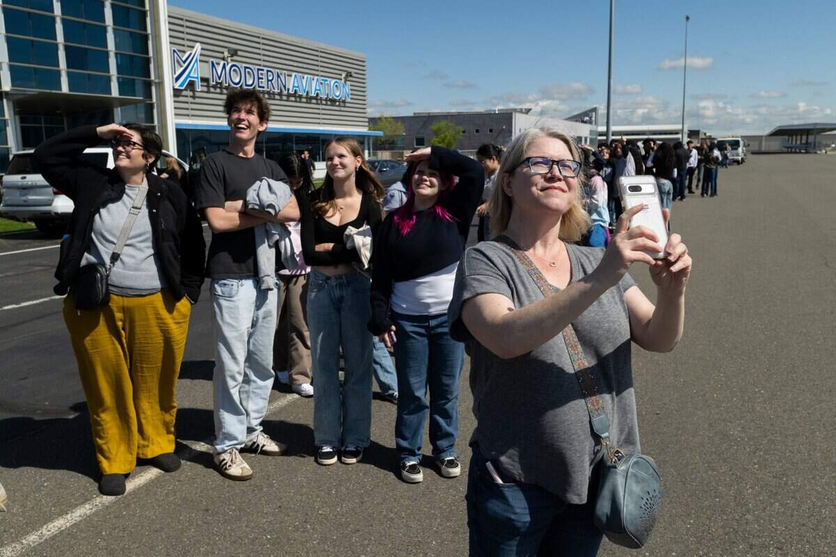 Heather McKnight takes video of her husband, teacher Jason McKnight, as he leaves on his 45-minute Blue Angels flight at Mather Airport on Tuesday.