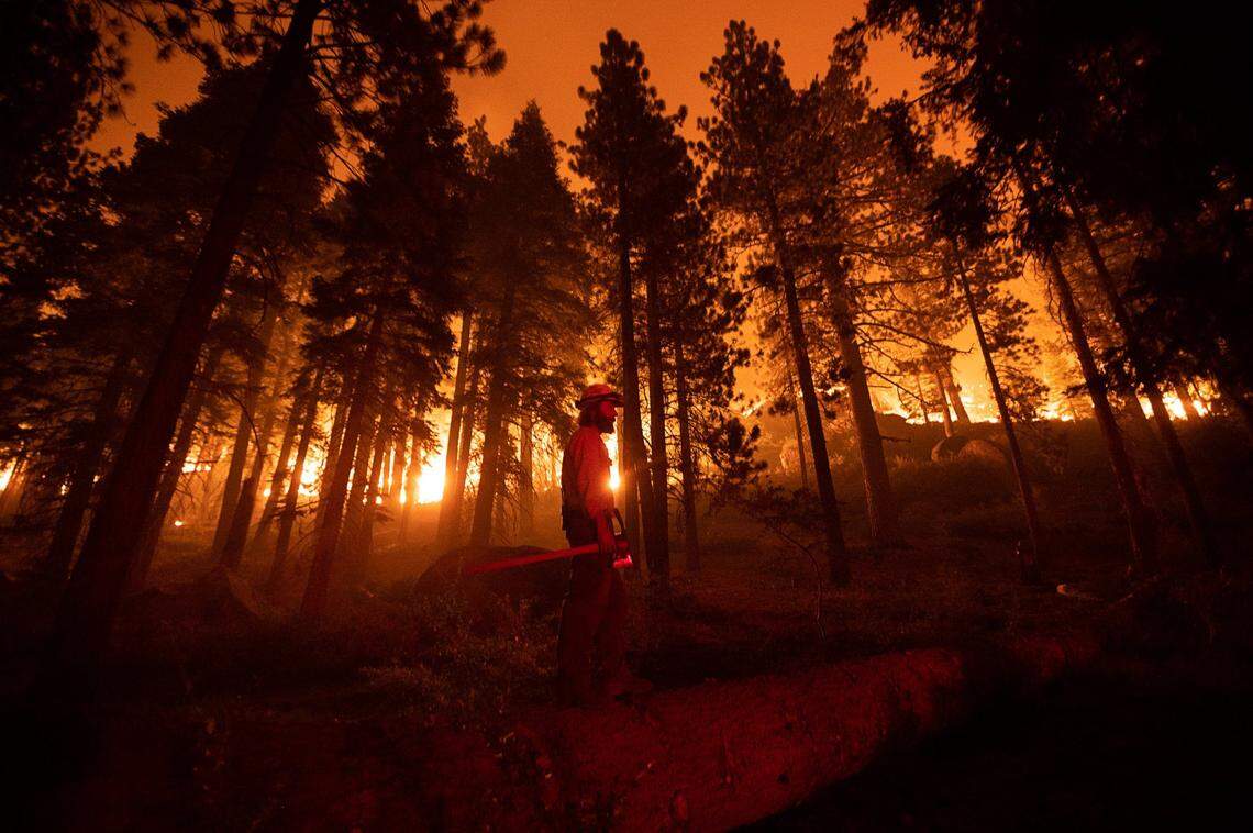 Dustin Johnston of the U.S. Forest Service Lake Tahoe Basin unit watches the Caldor Fire advance toward buildings near Meyers in 2021.