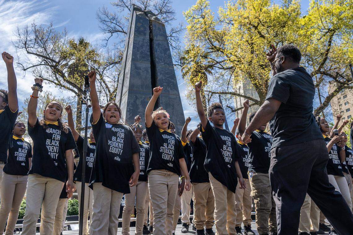 A.J. Johnson leads 4th and 5th graders from Alan Rowe College Prep in Elk Grove in the song “Stand Up” by Harriett Tubman at a Black in School Coalition rally and march against Gov. Gavin Newsom’s education budget proposal at Capitol Park in Sacramento on Tuesday, April 11, 2023.