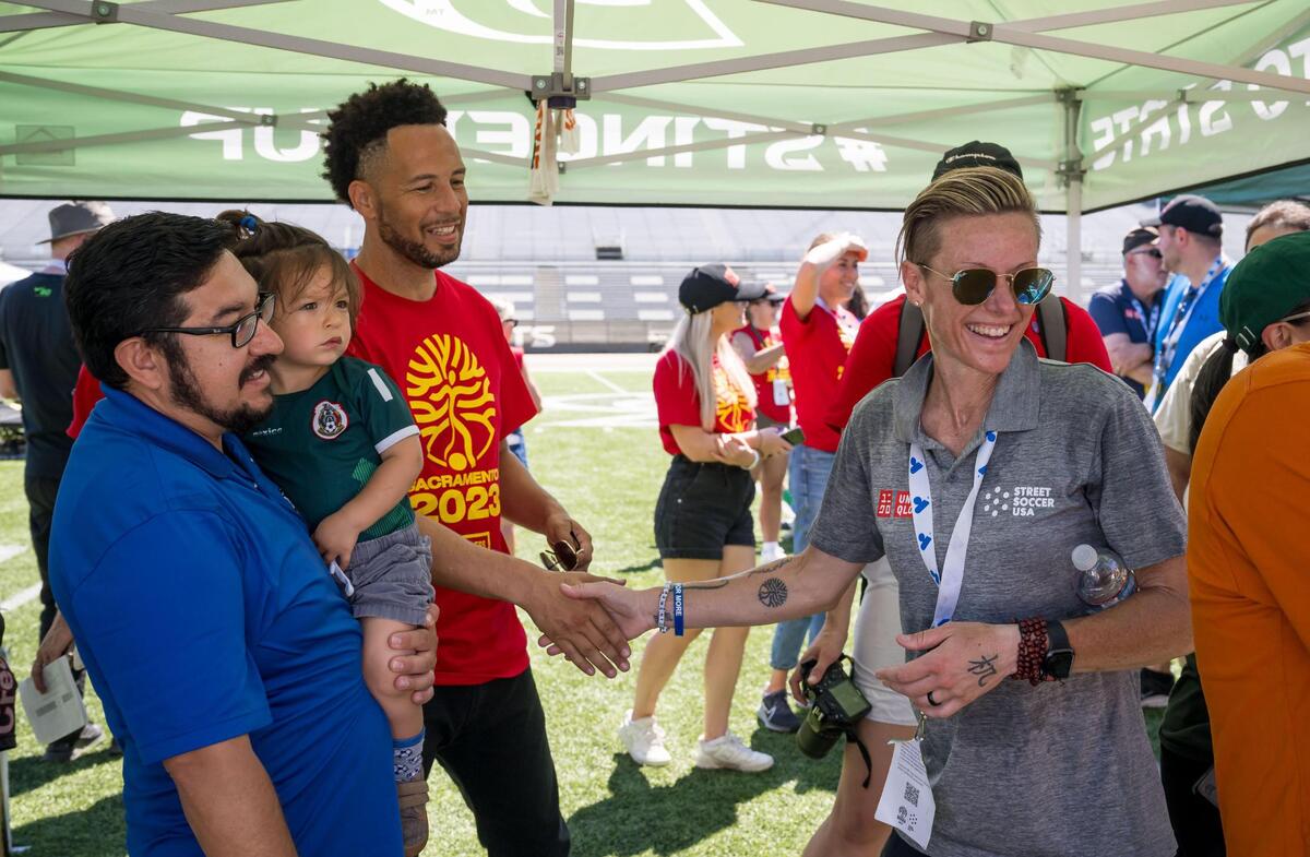 Lisa Wrightsman, a former player with the US women’s team and now Managing Director of the Sacramento Chapter of Street Soccer USA, is congratulated by Sacramento State President Luke Wood, center, and Sacramento City Councilmen Eric Guerra after the U.S. women’s win over Denmark on the final day of play at the Homeless World Cup on Saturday at Hornet Stadium at Sacramento State.