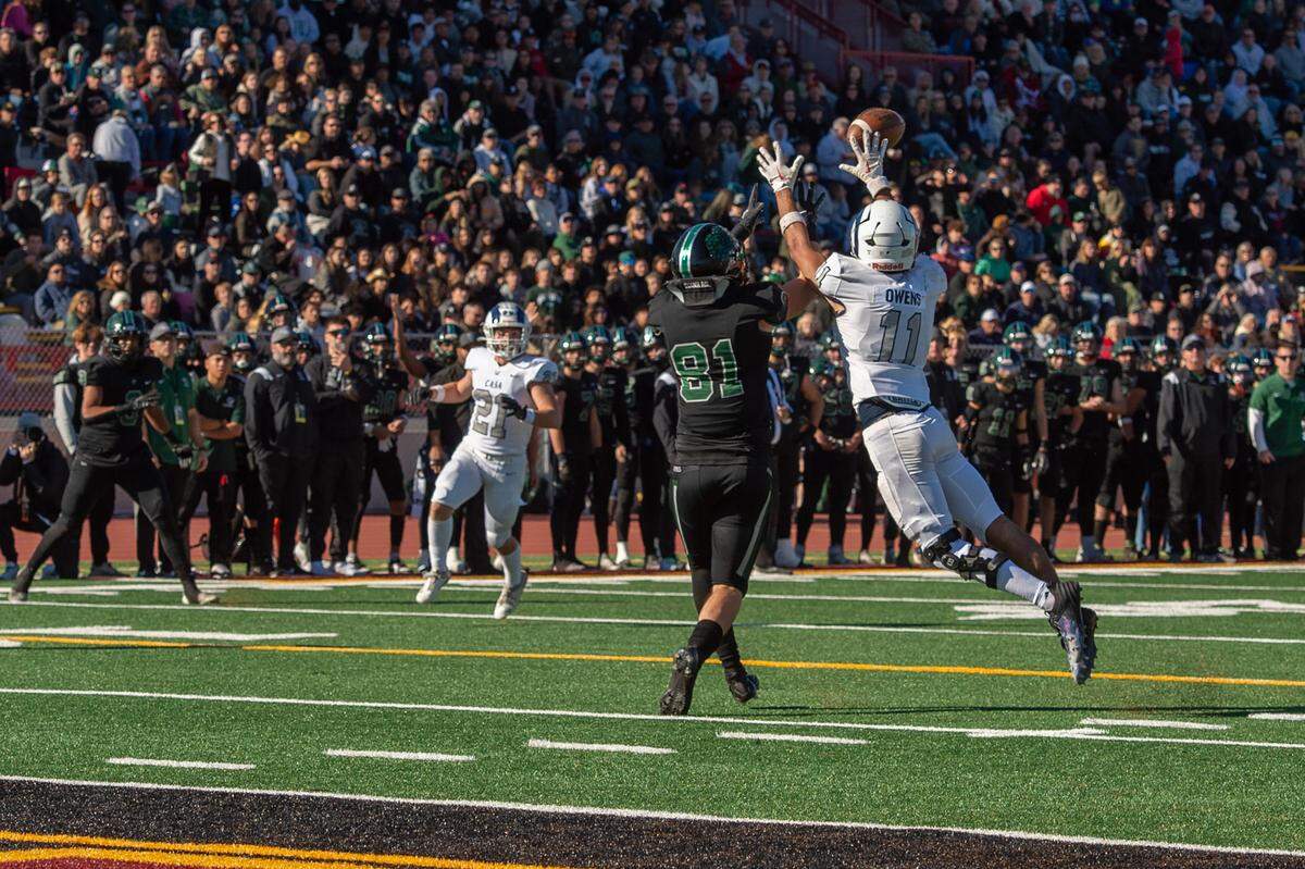 The Casa Roble Rams’ Cole Owens (11) jumps in front of Twelve Bridges Raging Rhinos receiver Mason Starbuck (81) for an interception near the goal line in the third quarter during the CIF Sac-Joaquin Section Division V football championship game on Friday at Hughes Stadium.