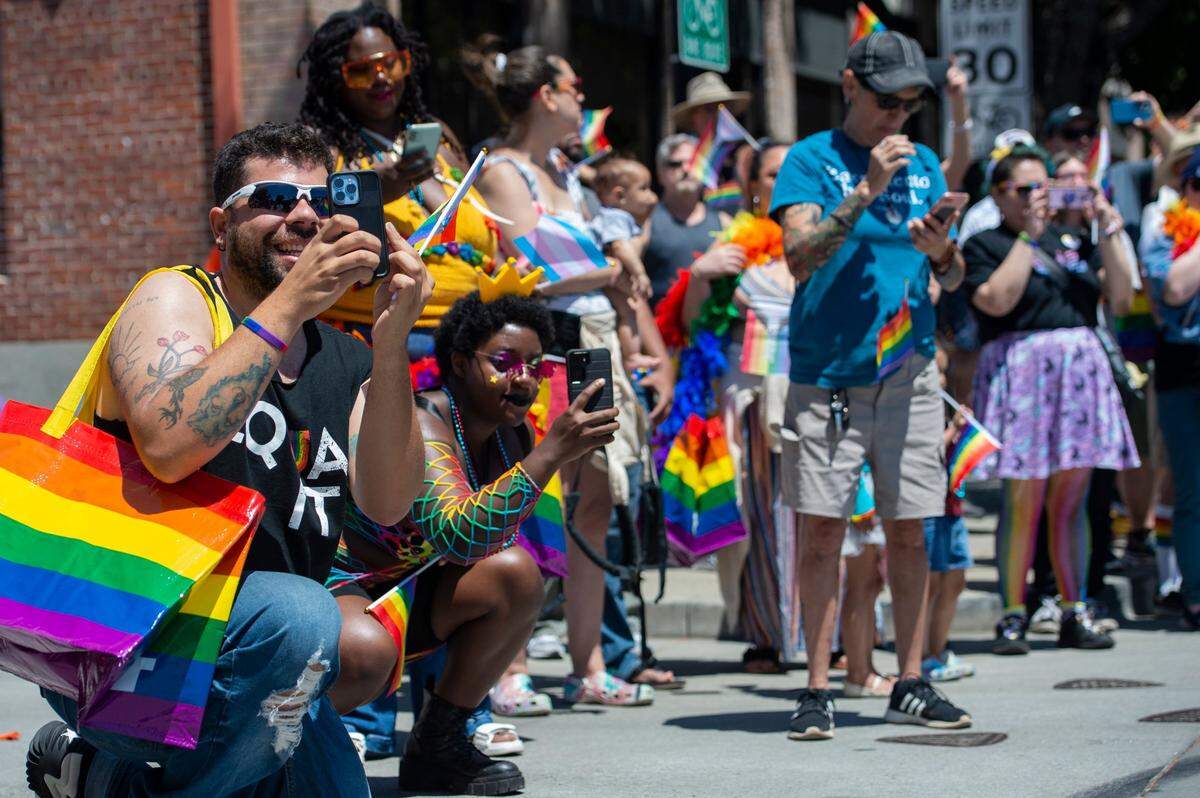 Spectators take photos as Sacramento Pride March and Parade passes R Street on Sunday, June 11, 2023.