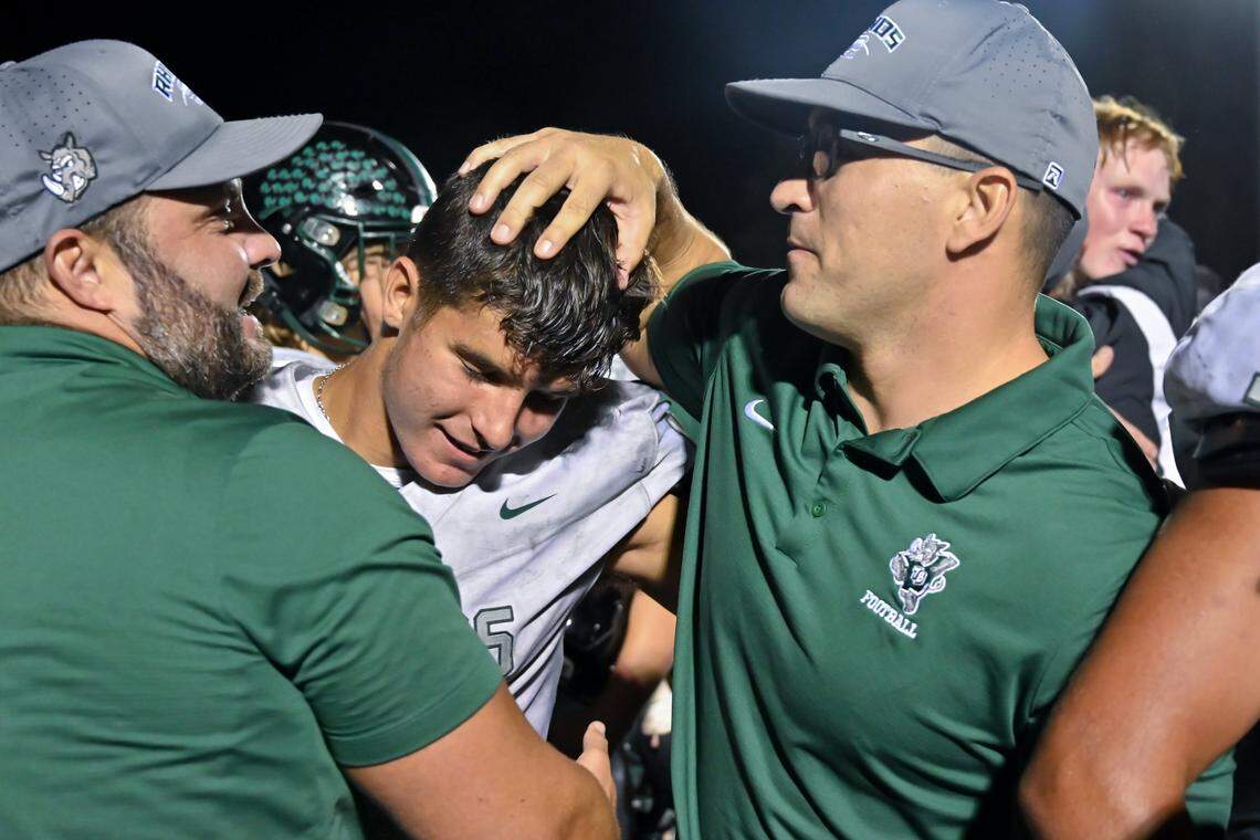 Twelve Bridges Raging Rhinos coaches congratulate running back Nathan Crawford (14) after a win against the Sutter Huskies for the league championship in October.