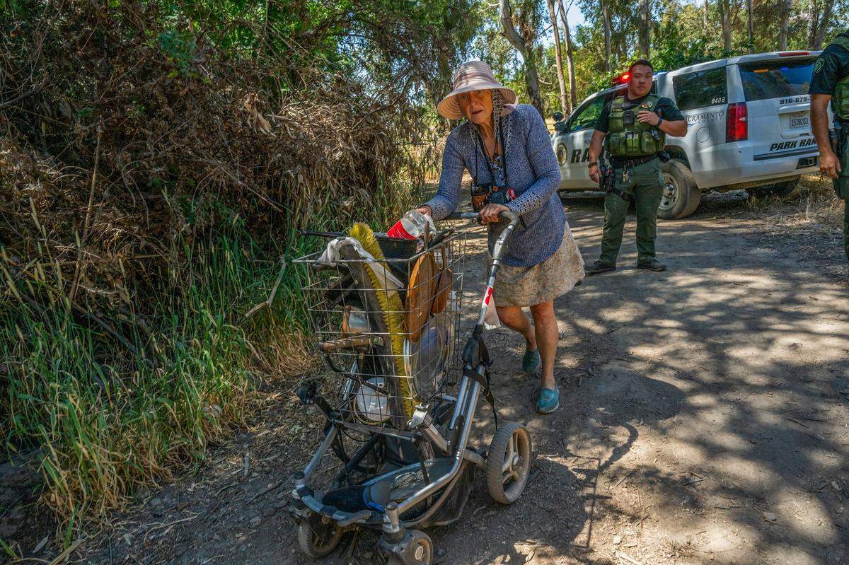 Carol Dutcher, 60, moves a few things away so they are not bulldozed during a sweep in a homeless encampment in Rio Linda on Monday, June 17, 2024. “They don’t care that they destroyed my home and I have no where to go or place to sleep tonight,” she said in tears. “Could you move your whole house in two days, four days? I don’t think anybody could,” she said.
