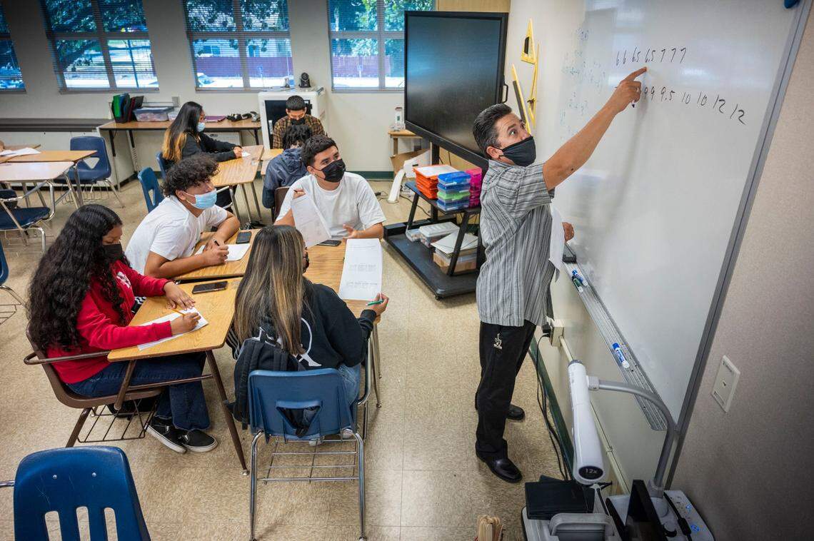 Math teacher Benito Dimas wears a mask as he instructs students in class at Hiram Johnson High School in Sacramento on June 6, the first day of a return to mandatory indoor masking at the Sacramento City Unified School District.