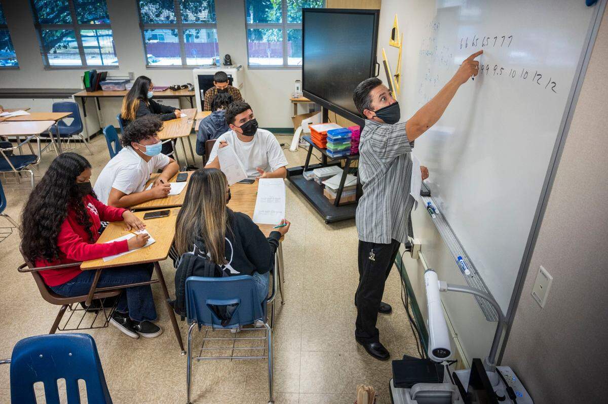 Math teacher Benito Dimas wears a mask as he instructs students in class at Hiram Johnson High School in Sacramento on Monday, June 6, 2022, on the first day of a return to mandatory indoor masking at the Sacramento City Unified School District.
