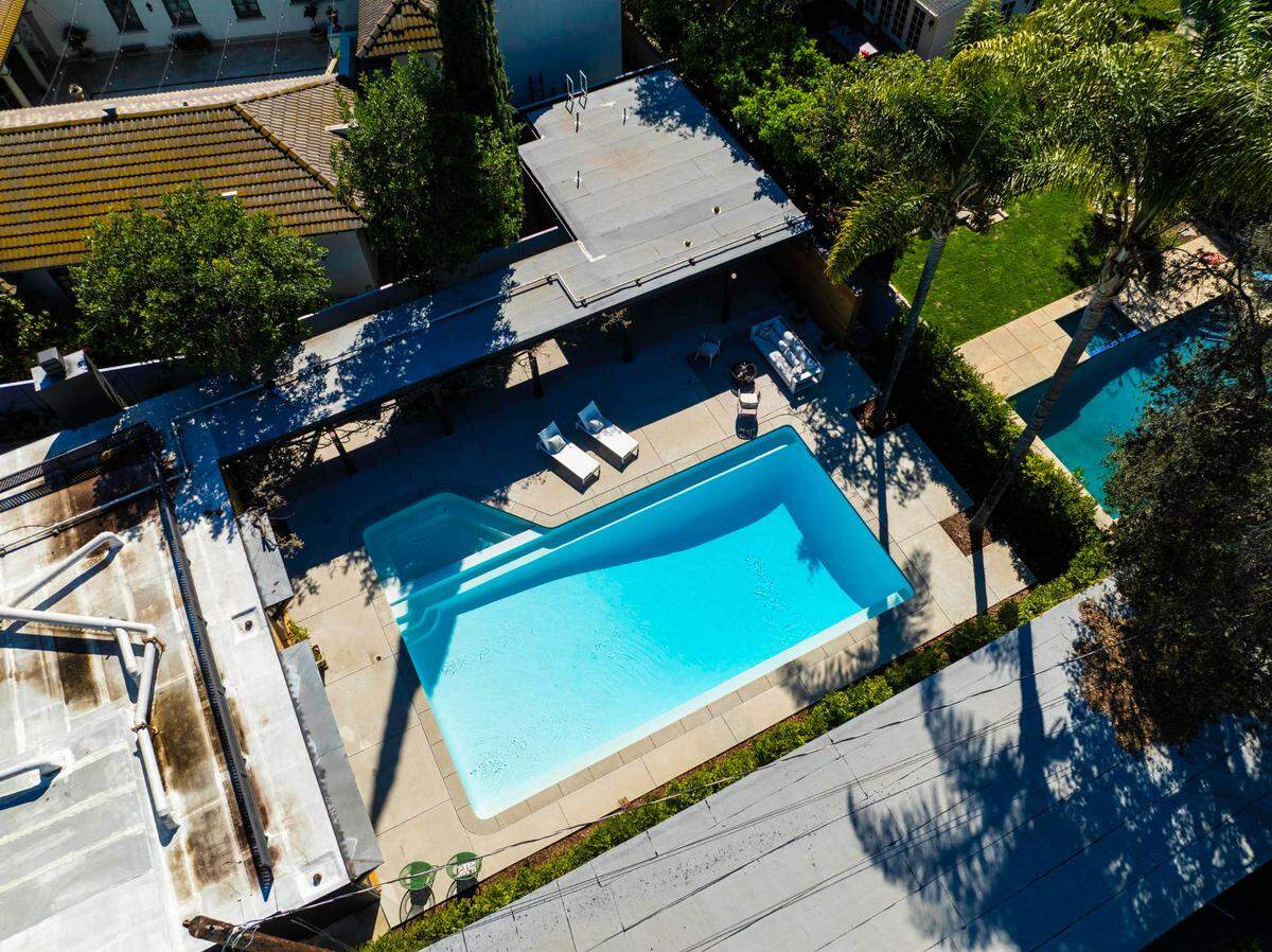A resort-style backyard boasts a 10-foot-deep pool, spa and lush landscaping.