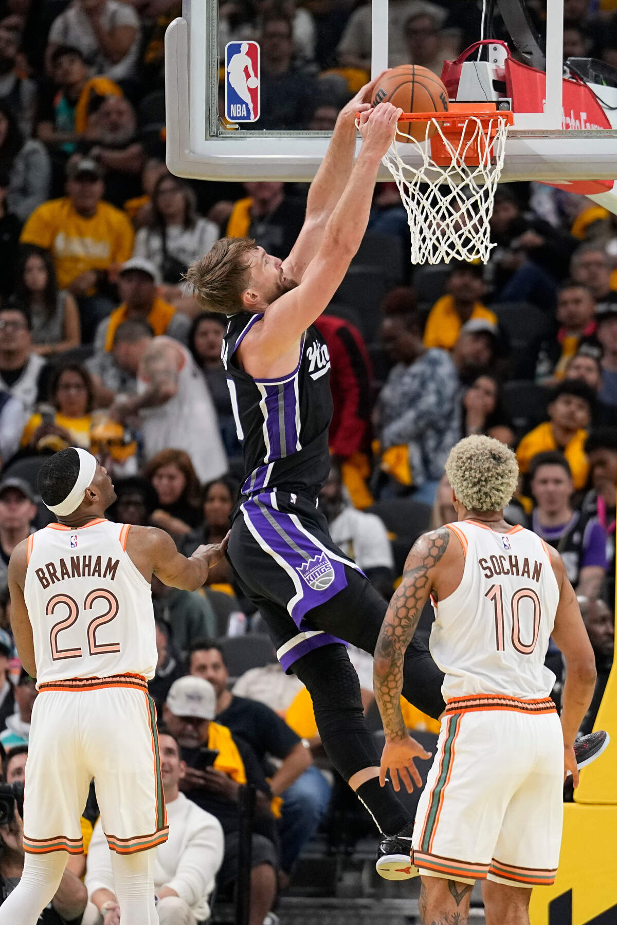 Sacramento Kings center Domantas Sabonis (10) dunks over San Antonio Spurs guard Malaki Branham (22) and forward Jeremy Sochan (10) during the first half Friday, Nov. 17, 2023, at Frost Bank Center in San Antonio, Texas.