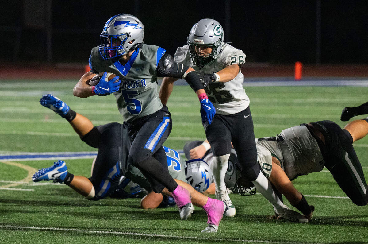 Rocklin Thunder running back Derek Keeley (5) escapes the Granite Bay Grizzlies’ CJ Ledell (25) for a first down in the third quarter on Friday, Oct. 19, 2024, in Rocklin.