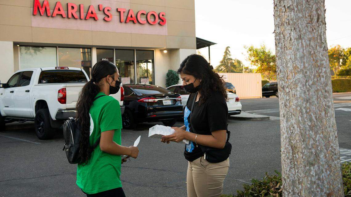 Melissa Lopez, left, and Alma Gallegos get ready to distribute COVID-19 tests to a taco shop in Fresno. Both are seniors at Theodore Roosevelt High School participating in the Promotoritos program, an internship organized by the nonprofit Fresno Building Healthy Communities.