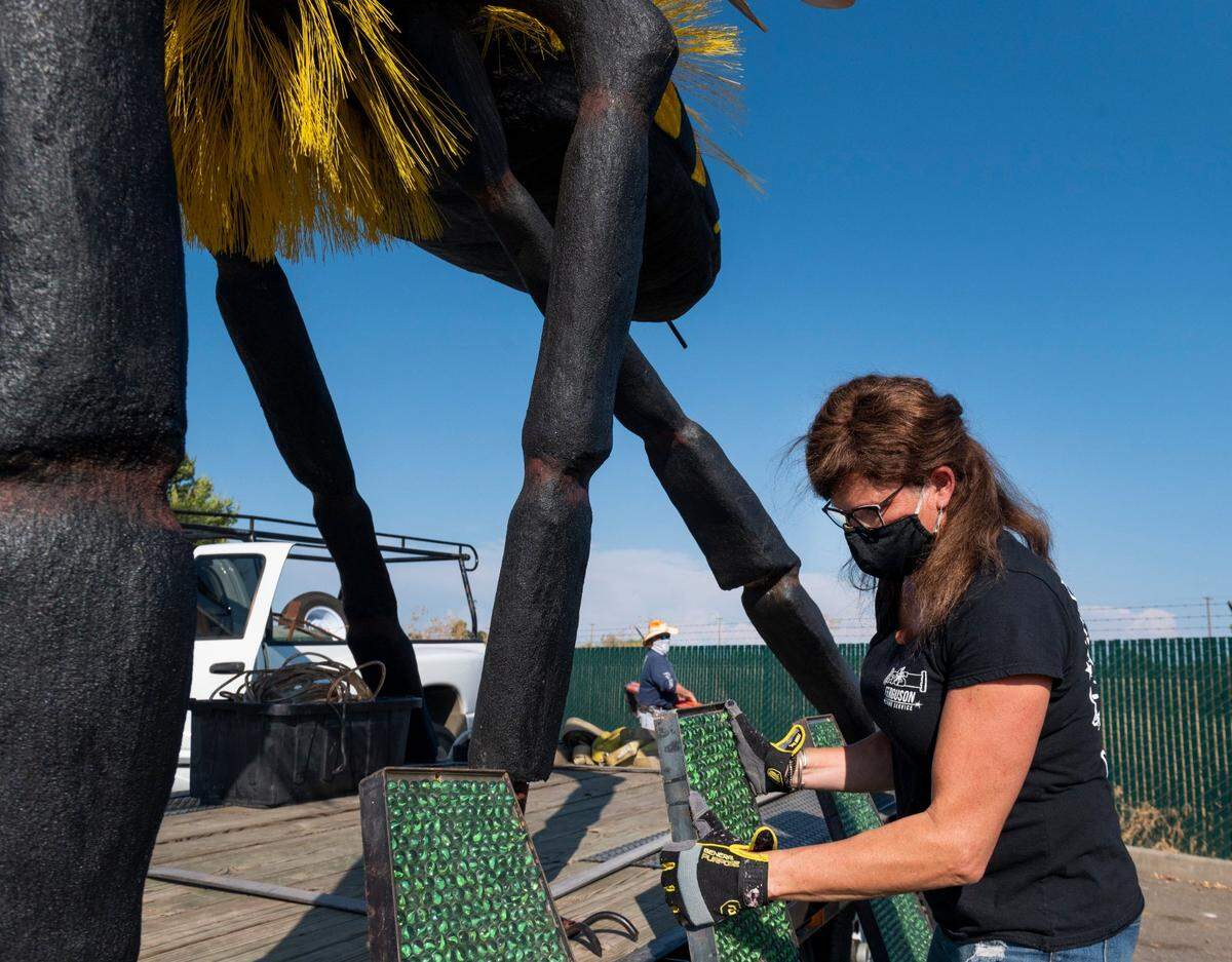 Lisa Ferguson, front, and her husband, Robert, set up their “Bee or Not to Bee” sculpture at Summer Spark, a nighttime drive-thru festival inspired by Burning Man, at the Mine Shaft Center in Rancho Cordova on Friday, July 24, 2020. The sculpture was displayed at Burning Man in 2019.