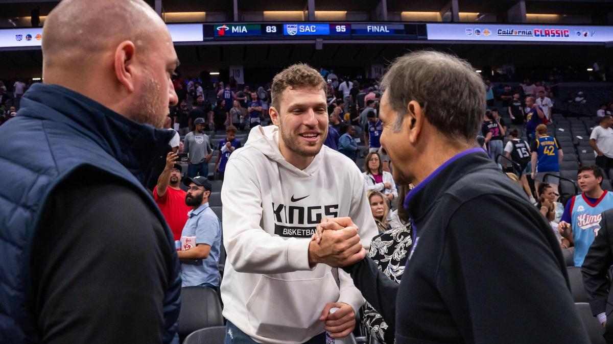 EuroLeague MVP and incoming Sacramento King Sasha Vezenkov shakes hands with owner Vivek Ranadivé, right, after sitting with general manager Monte McNair, left, for most of the California Classic NBA summer league basketball game between the Kings and the Miami Heat on Wednesday, July 5, 2023, at Golden 1 Center.