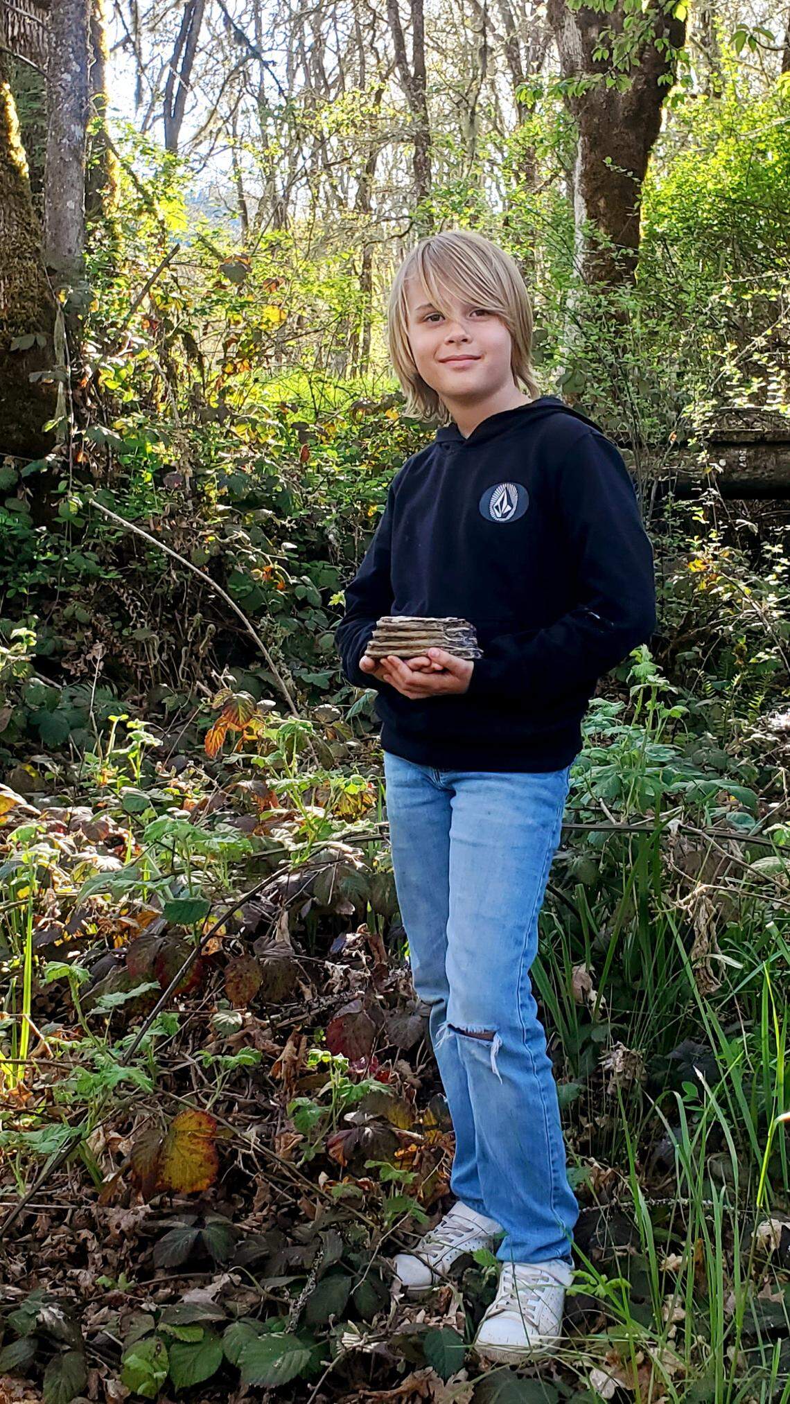 Jeremiah Longbrake, 9, poses with the mammoth tooth fragment he found while exploring his grandmother’s backyard.