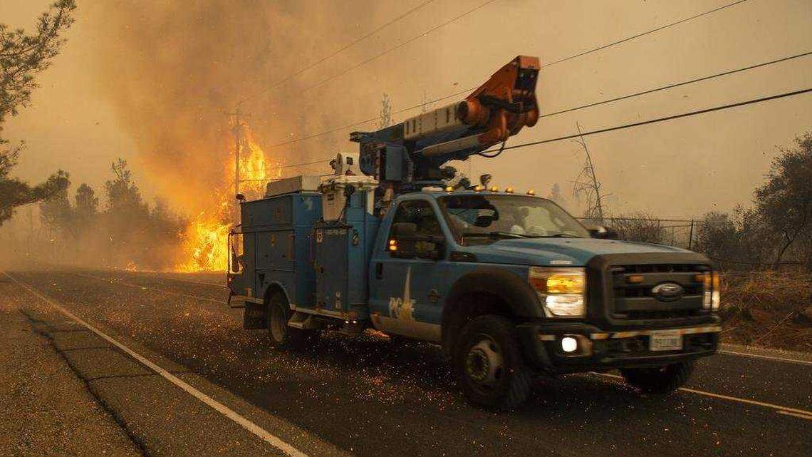 A Pacific Gas and Electric truck makes its way past a hot spot during the Camp Fire in Paradise in November 2018.