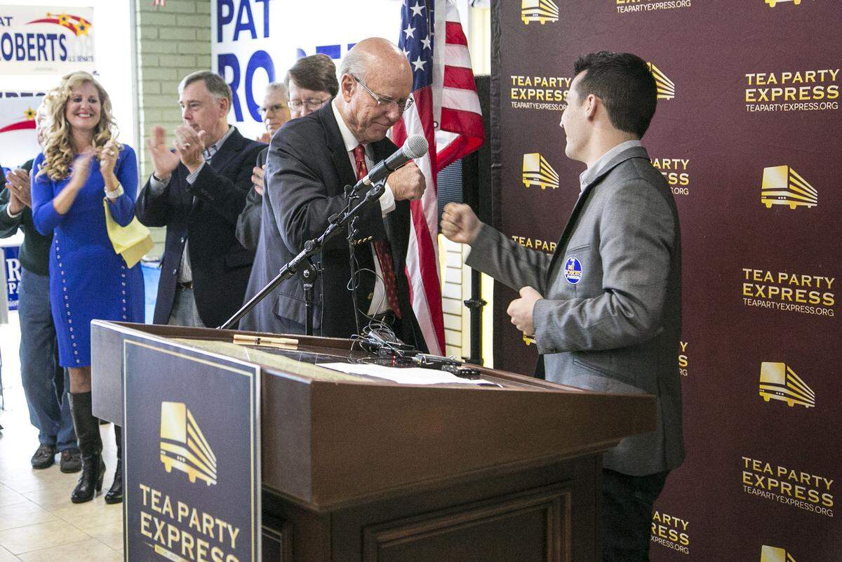 Sen. Pat Roberts fist bumps Taylor Budowich, then the executive director of the Tea Party Express, during an announcement in 2014 that the group has switched its endorsement to the senator after supporting a primary opponent earlier in the year.