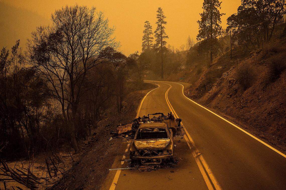 A scorched pickup truck rests on California Highway 96 in Klamath National Forest as the McKinney Fire burns nearby on Saturday.