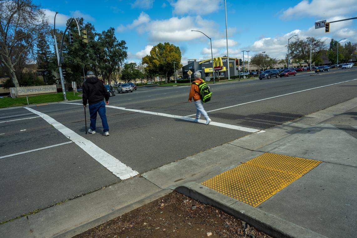 Pedestrians walk in March across a crosswalk in Rosemont where, in 2023, Andrew Pringle, 21, was struck and killed by a car that ran a red light. His older sister, Erika Pringle, hopes a pedestrian bridge could be built in the area to help prevent future road deaths.