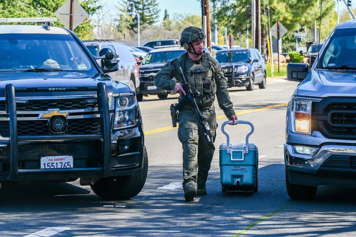 An officer pulls an ice chest after gunfire erupted at the Hazel Ranch apartment complex in the 8800 block of Winding Way in Fair Oaks on Friday.