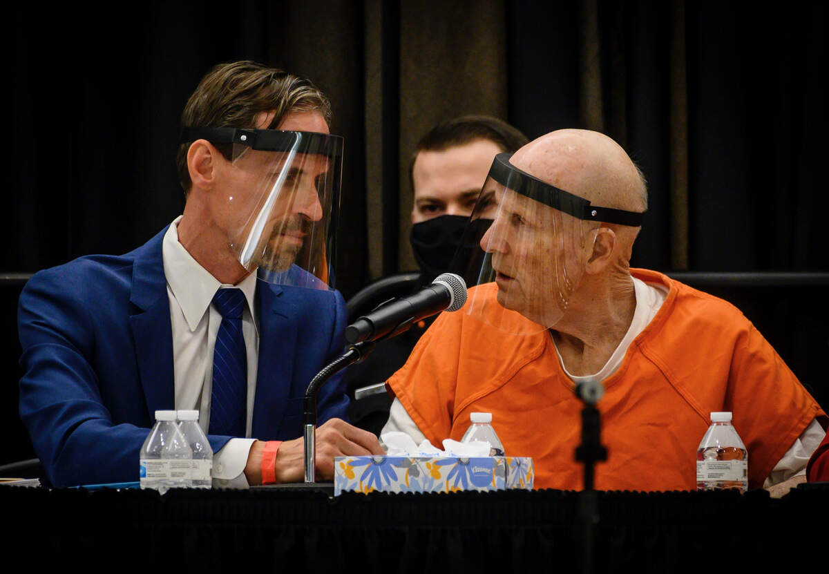 Joseph James DeAngelo, wearing a face shield, confers with public defender Joseph Cress in a makeshift courtroom at Sacramento State where he admitted that he was the Golden State Killer and pleaded guility to numerous charges of murder, rape and other crimes in 2020.
