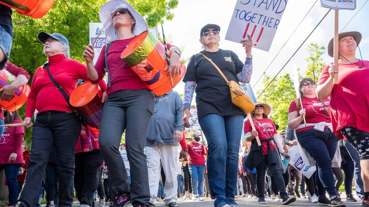 Los participantes de una marcha y manifestación en Hiram Johnson High School caminan hacia la oficina de transporte el martes 29 de marzo de 2022, en Sacramento, durante la huelga de la Asociación de Maestros de la Ciudad de Sacramento y el SEIU Local 1021.