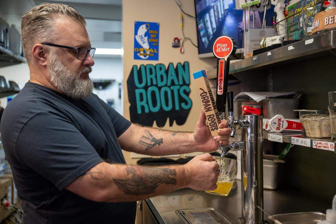 Scott Macumber pours a Urban Roots beer for a customer at Pangaea Bier Cafe last month.
