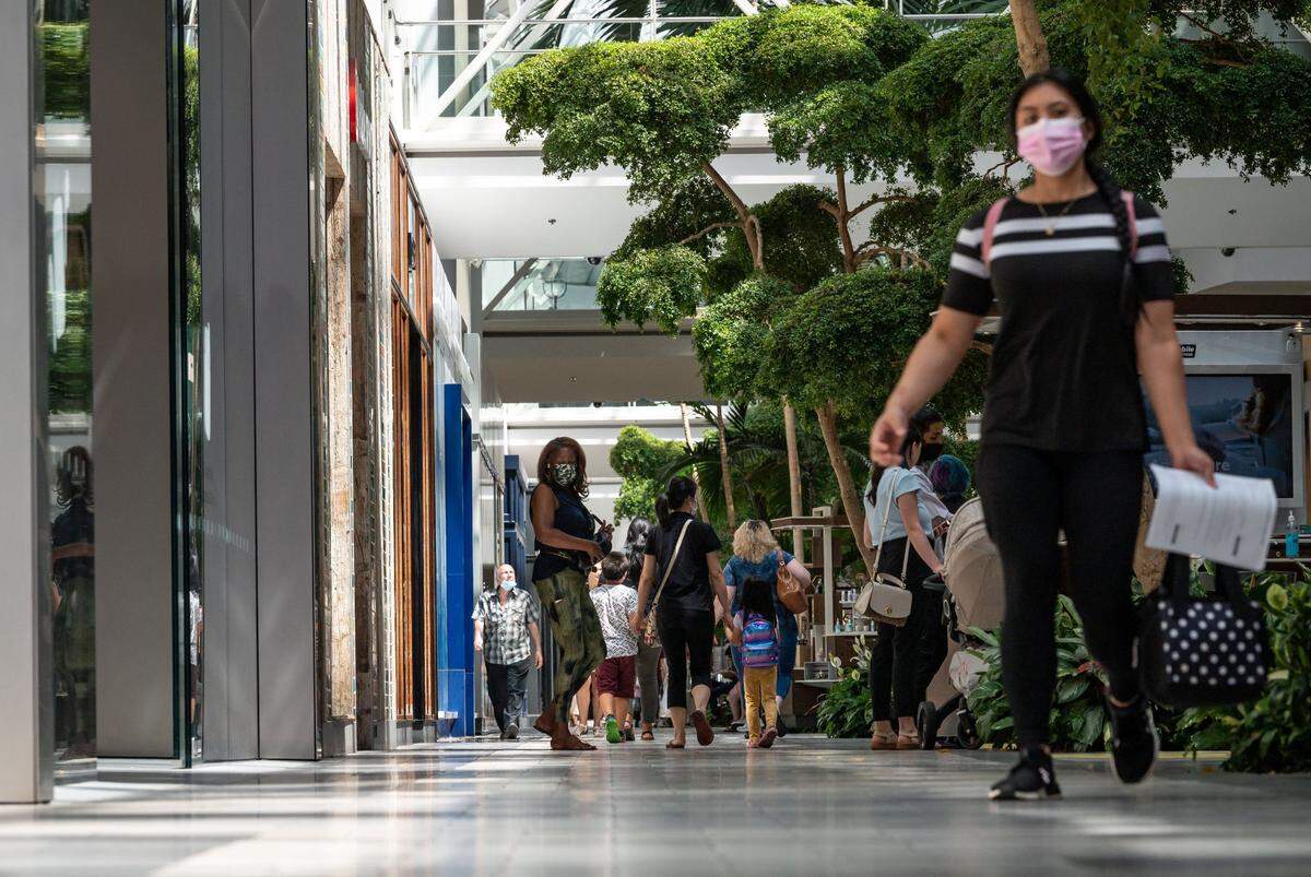 Masked and unmasked shoppers and employees move about Arden Fair mall on Tuesday, June 22, 2021, in Sacramento.