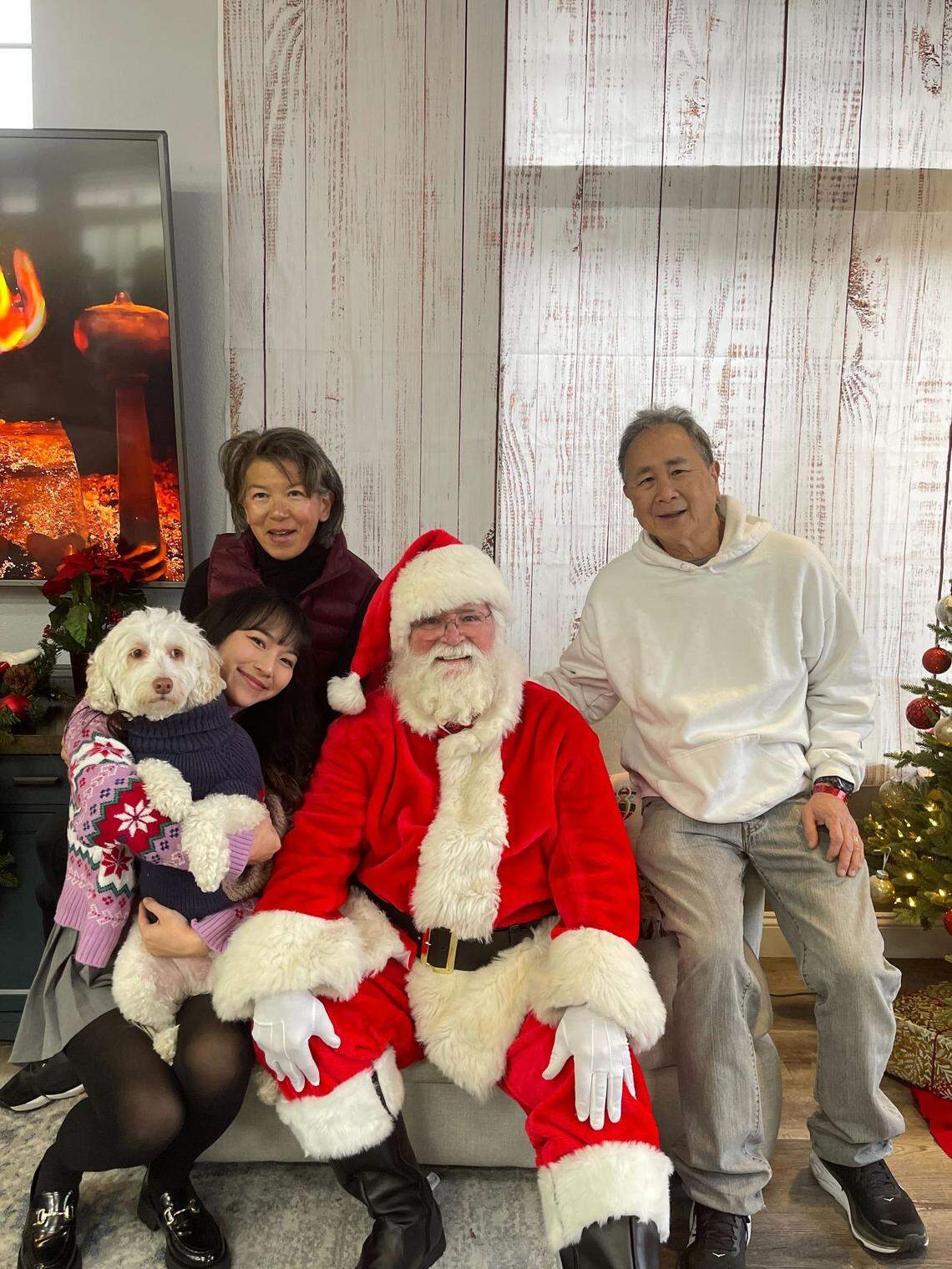 The Chan family, along with their dog Biscuit, visits with Santa. Biscuit won the Paw-lidays pet photo competition, in collaboration with Us Weekly.