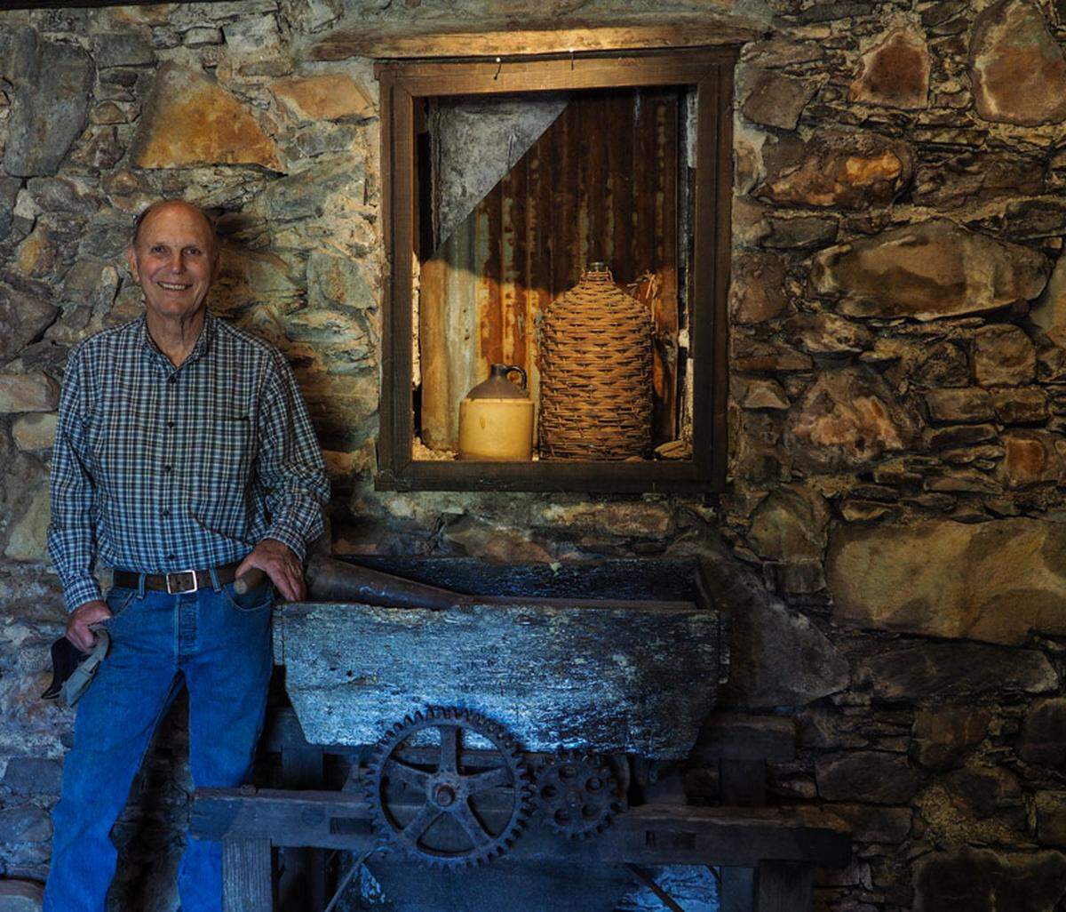 Greg Boeger next to a Gold Rush-era grape press in the original stone cellar on the property now home to Boeger Winery.