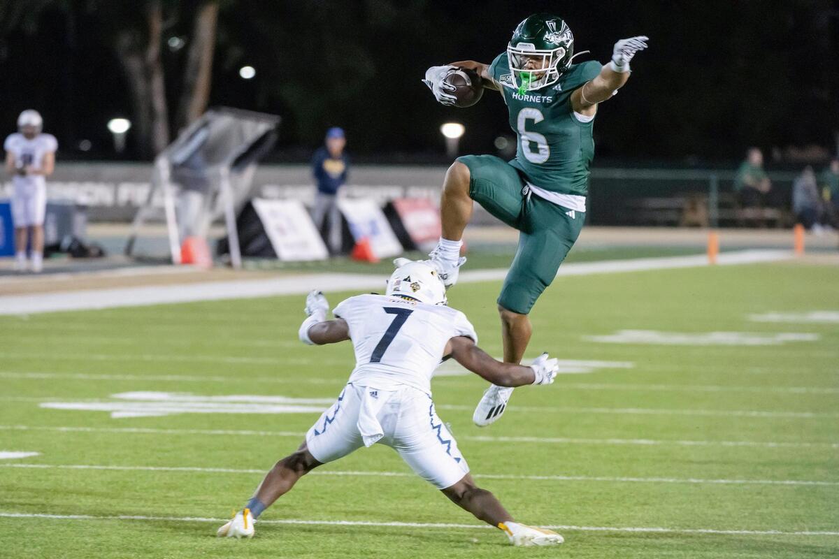 The Sacramento State Hornets running back Ezra Moleni (6) jumps over the Northern Arizona Lumberjacks’ David Spruiells (7) in the first half of the NCAA football game at Hornet Stadium on Saturday, Sept. 30, 2023.