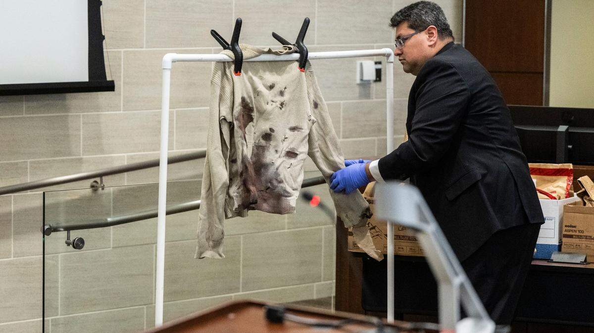 Davis Police Department detective Alex Torres describes the evidence of knife stabbings on a long-sleeve shirt that was worn by David Breaux, allegedly fatally stabbed by former UC Davis student Carlos Reales Dominguez, during the first day of trial at Yolo Superior Court in Woodland on Monday.