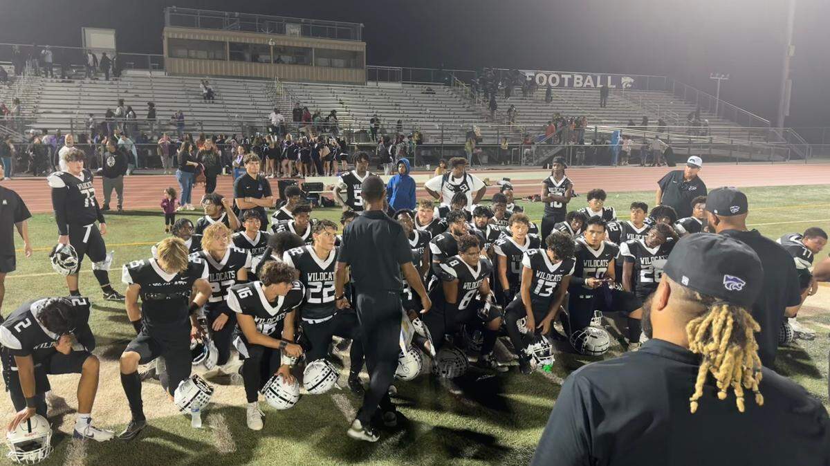 The Franklin Wildcats take a knee after defeating the Davis Blue Devils, 50-8, on Friday at Cosumnes Oaks High School in Elk Grove.