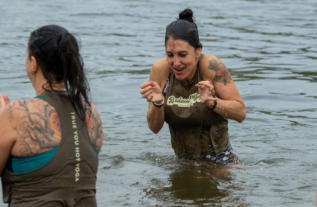 Renée Marie of Stockton, right, reacts to the cold after taking her first-ever polar bear plunge into the cold water at Lake Natoma in Folsom on New Year’s Day.