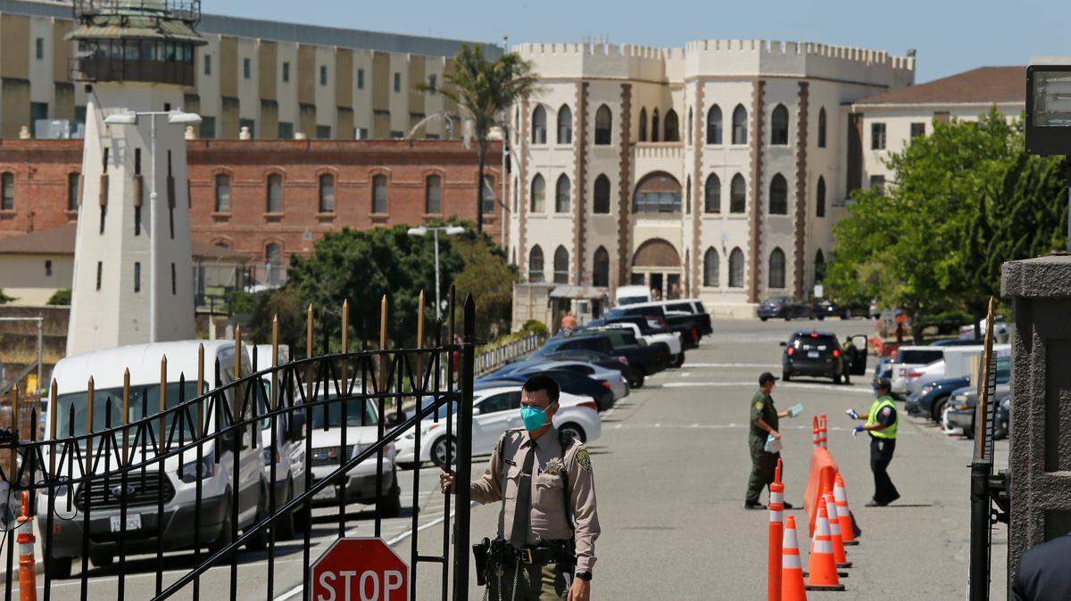 FILE - This July 9, 2020, file photo shows a correctional officer closing the main gate at San Quentin State Prison in San Quentin, Calif. (AP Photo/Eric Risberg, File)