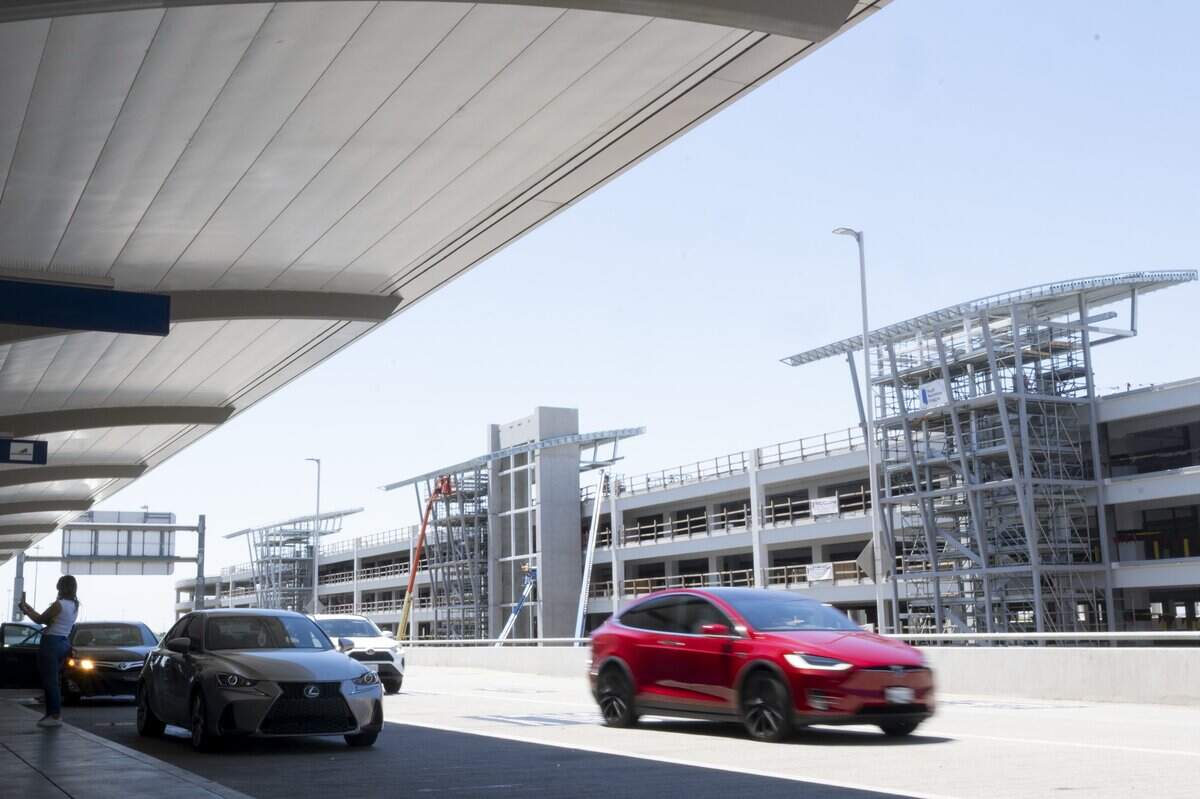 Cars arriving at the departure gates pass in front of the new parking garage currently under construction at Sacramento International Airport on Wednesday, June 17.