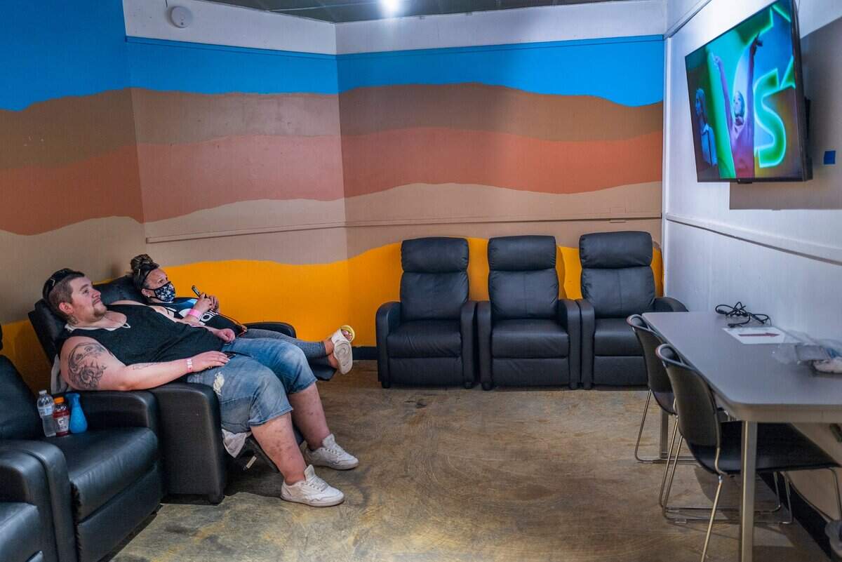 Victor Koutsis, left, and Kristin Goree watch TV as they cool off in the city of Sacramento’s Outreach and Engagement Center at 3515 Auburn Blvd. on Monday, July 11, 2022. The homeless couple have been living in their car for the past three years and were happy to find a place close to Carmichael Park, where they were staying. They said the car was too hot for their two dogs on a day with a high temperature of 102 degrees. Im very appreciative, thats for sure, said Goree.