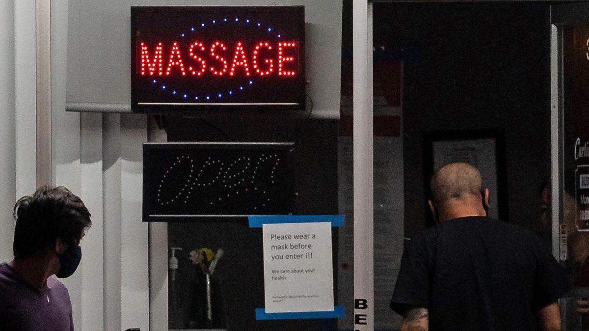 A woman opens the door as a man walks in a Sacramento massage in 2020. Hundreds of new massage businesses have opened in Sacramento in recent years and the City Council is considering a new ordinance regulating the industry.