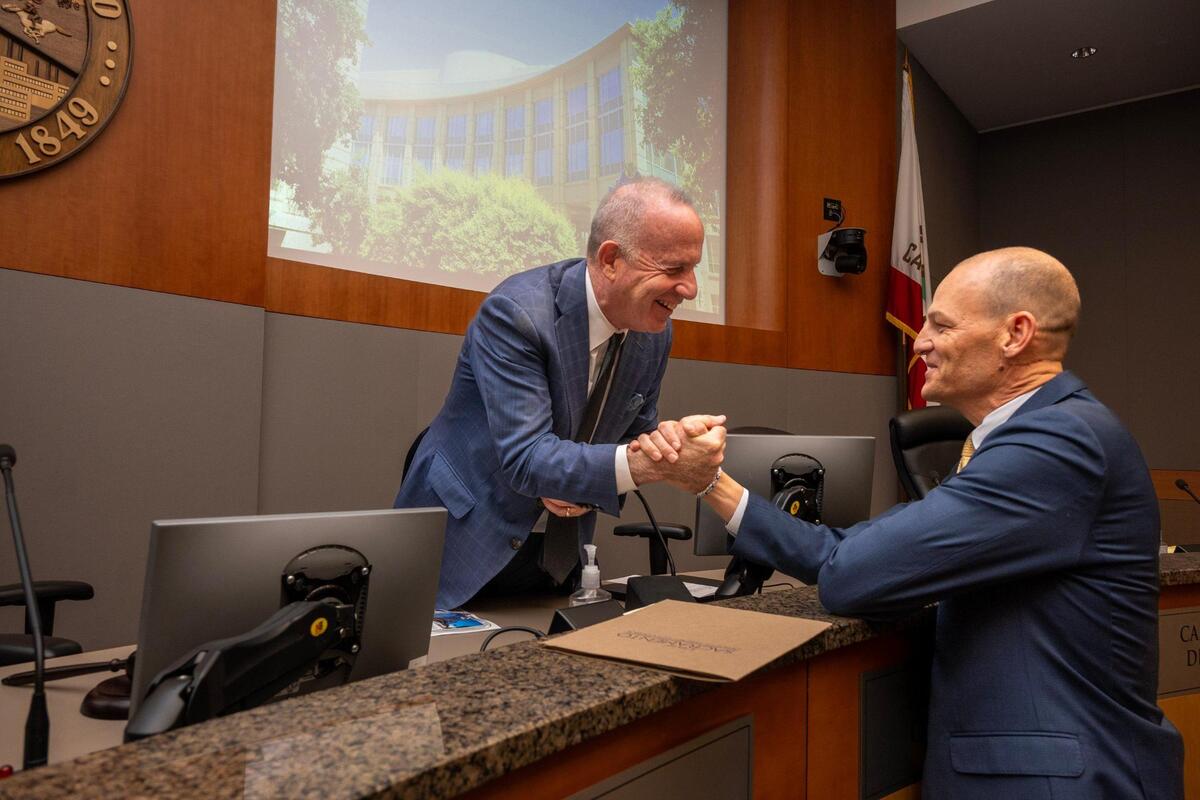Outgoing mayor Darrell Steinberg shakes hands with Mayor-elect Kevin McCarty before the Sacramento City Council swearing-in ceremony on Tuesday night.